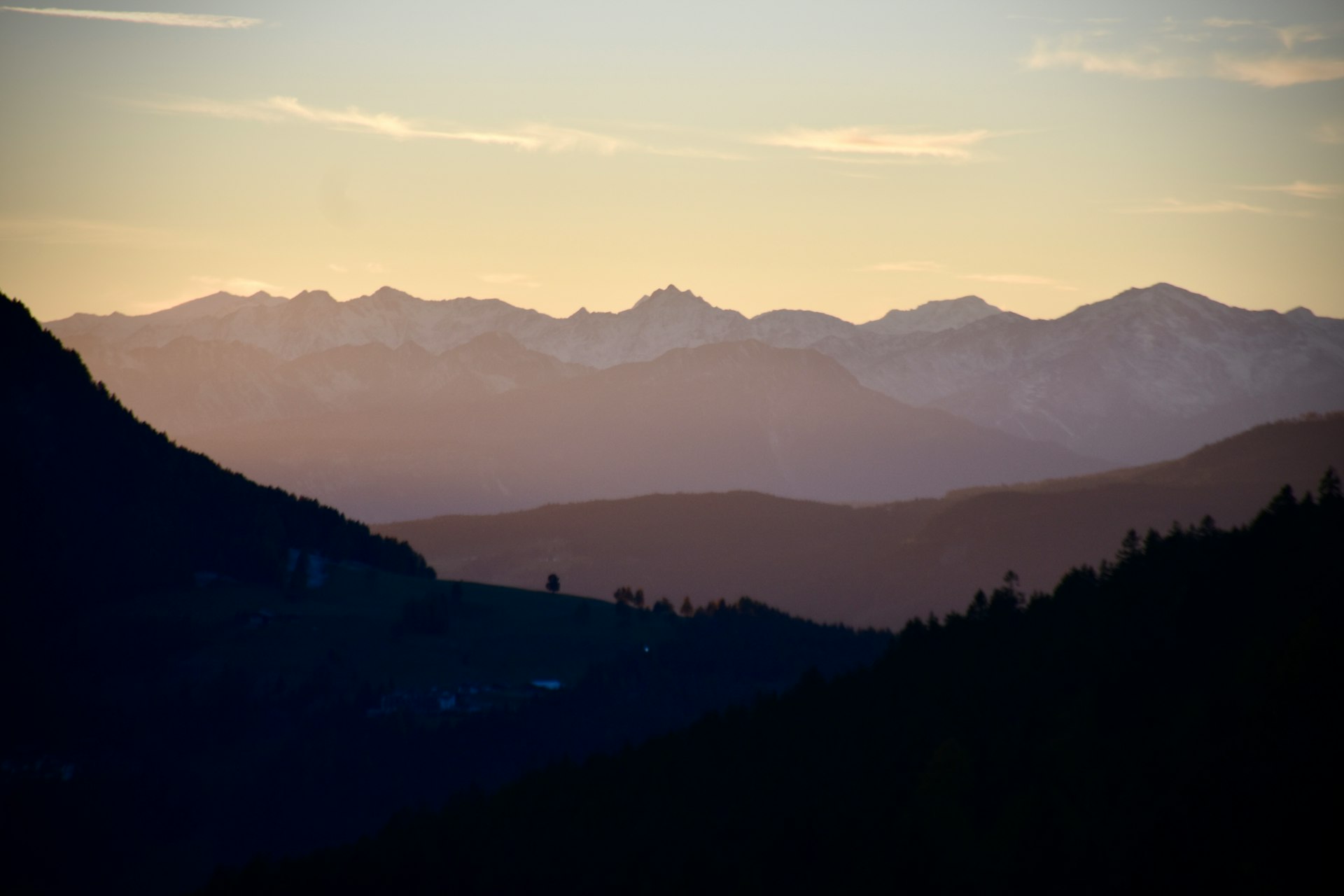 Le creste delle montagne al tramonto, con i boschi scuri in primo piano