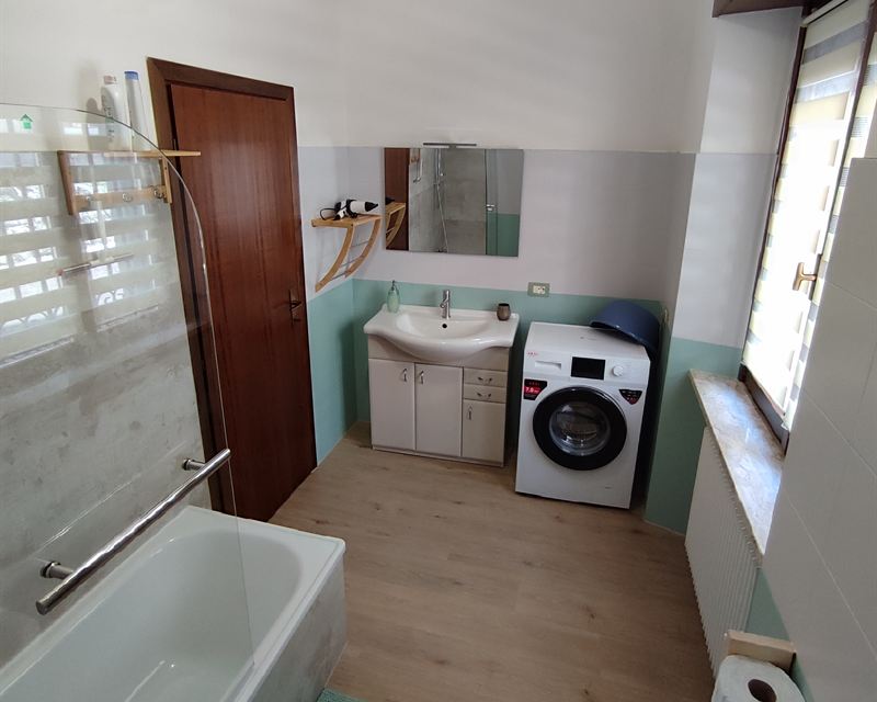 Il bagno con lavabo e lavatrice