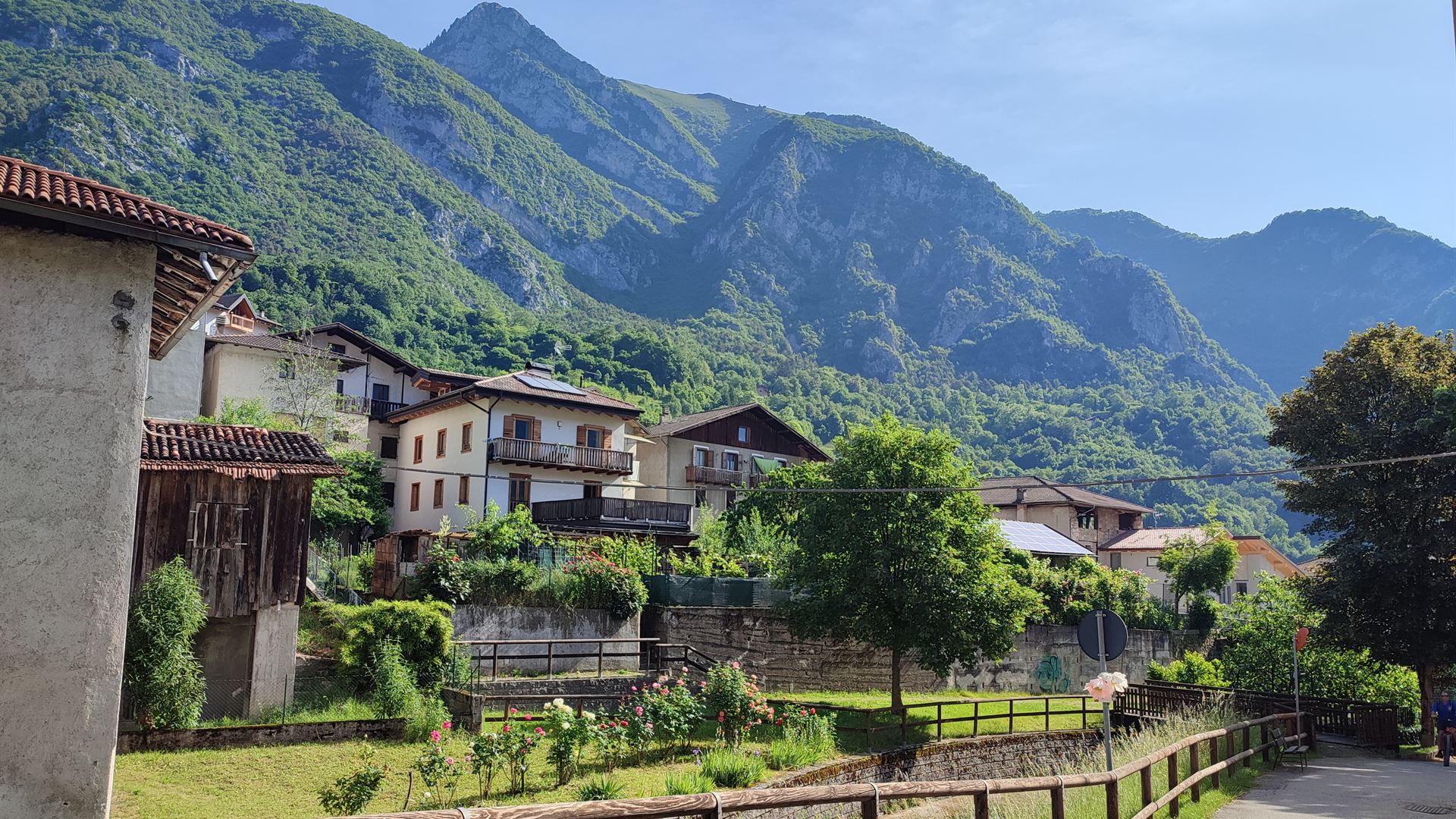 Le case di Molina di Ledro ai piedi delle montagne, con i giardini e il sentiero